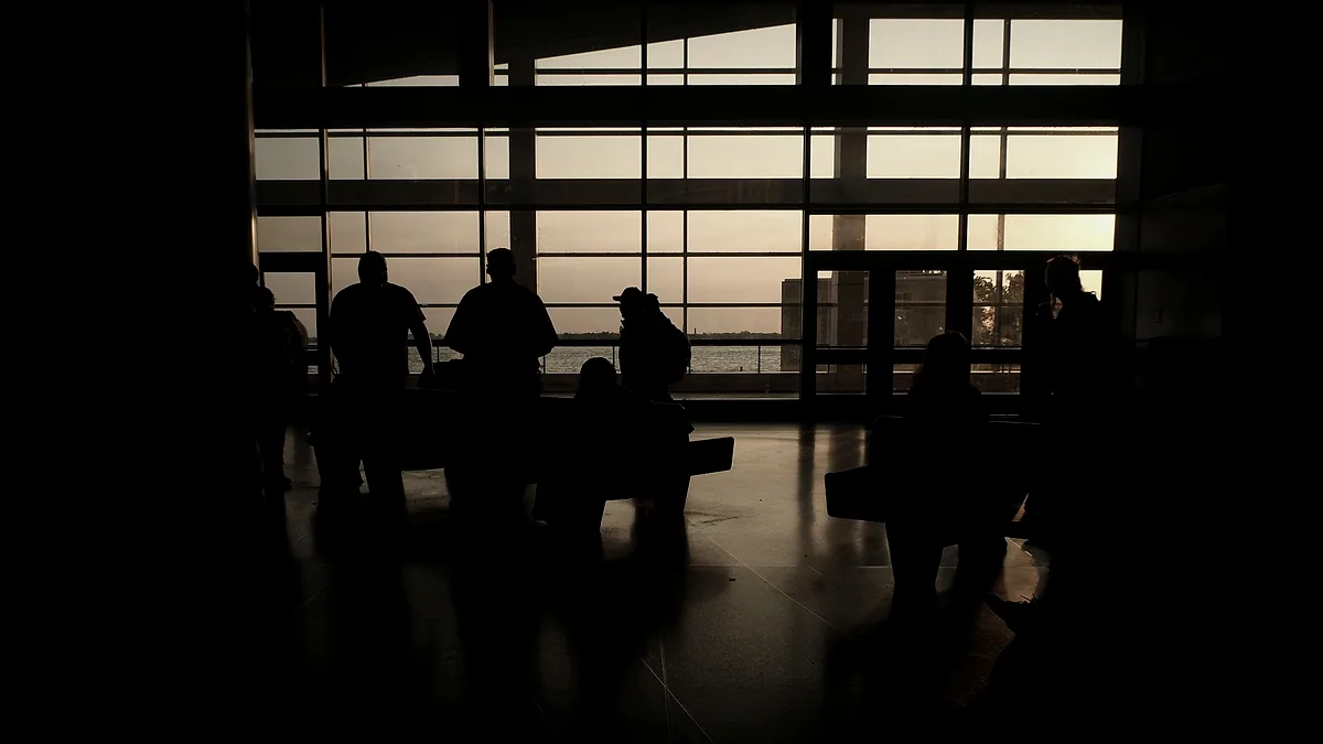 Figures gathered at a window in a working space