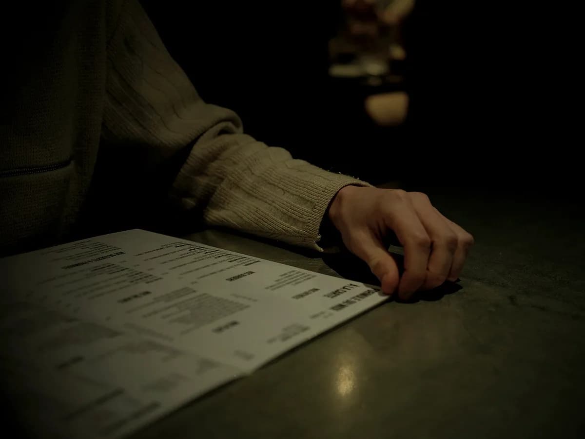Hands working through printed documents on a desk